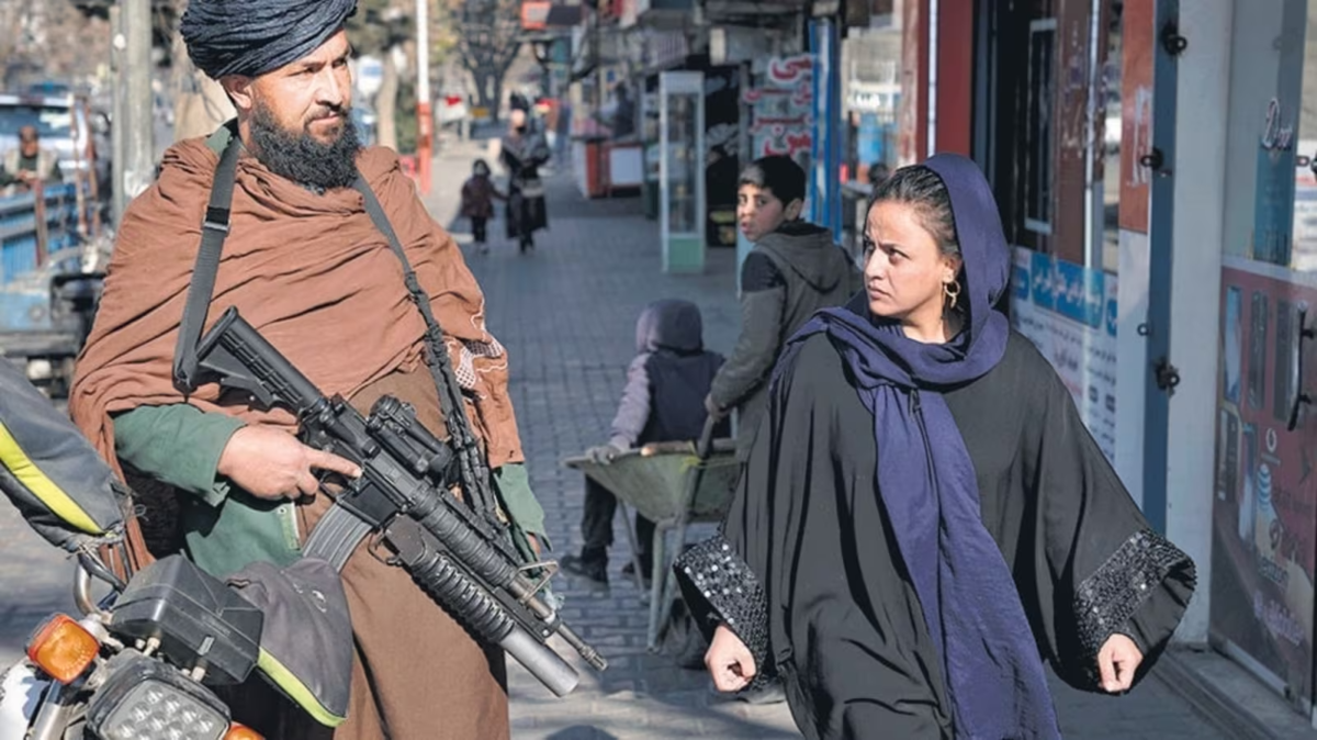 A woman in Afghanistan being escorted by an armed male Taliban counterpart. Women's movements and involvement in society has been restricted by the Taliban. 