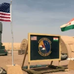 In this file photo taken Monday, April 16, 2018, a US and Niger flag are raised side by side at the base camp for air forces and other personnel supporting the construction of Niger Air Base 201 in Agadez, Niger.