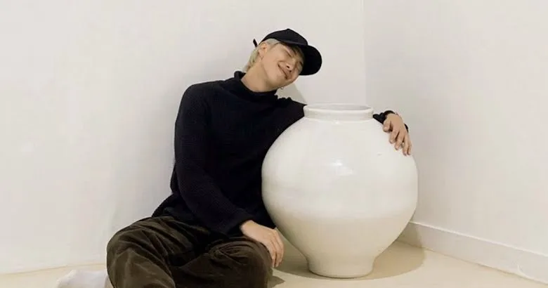RM from BTS band posing with one of his moon jars