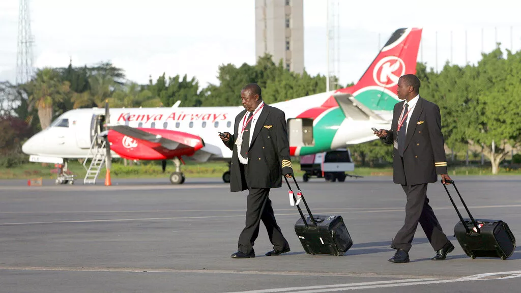 Kenyan Airways pilots check their mobile phones as the walk. [Photo/Courtesy] County