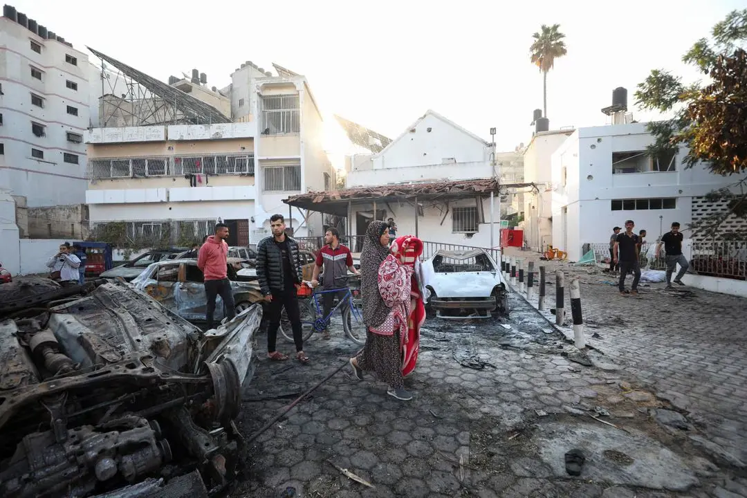People inspect the area of Al-Ahli hospital where hundreds of Palestinians were killed in a blast that Israeli and Palestinian officials blamed on each other, and where Palestinians who fled their homes were sheltering amid the ongoing conflict with Israel, in Gaza City, October 18, 2023. [Photo/REUTERS]