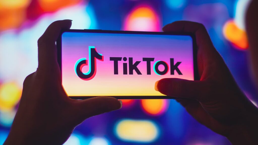 TikTok logo on a smartphone screen, symbolising the platform's use of AI moderation to identify harmful and misleading content and its global removal of millions of videos.
